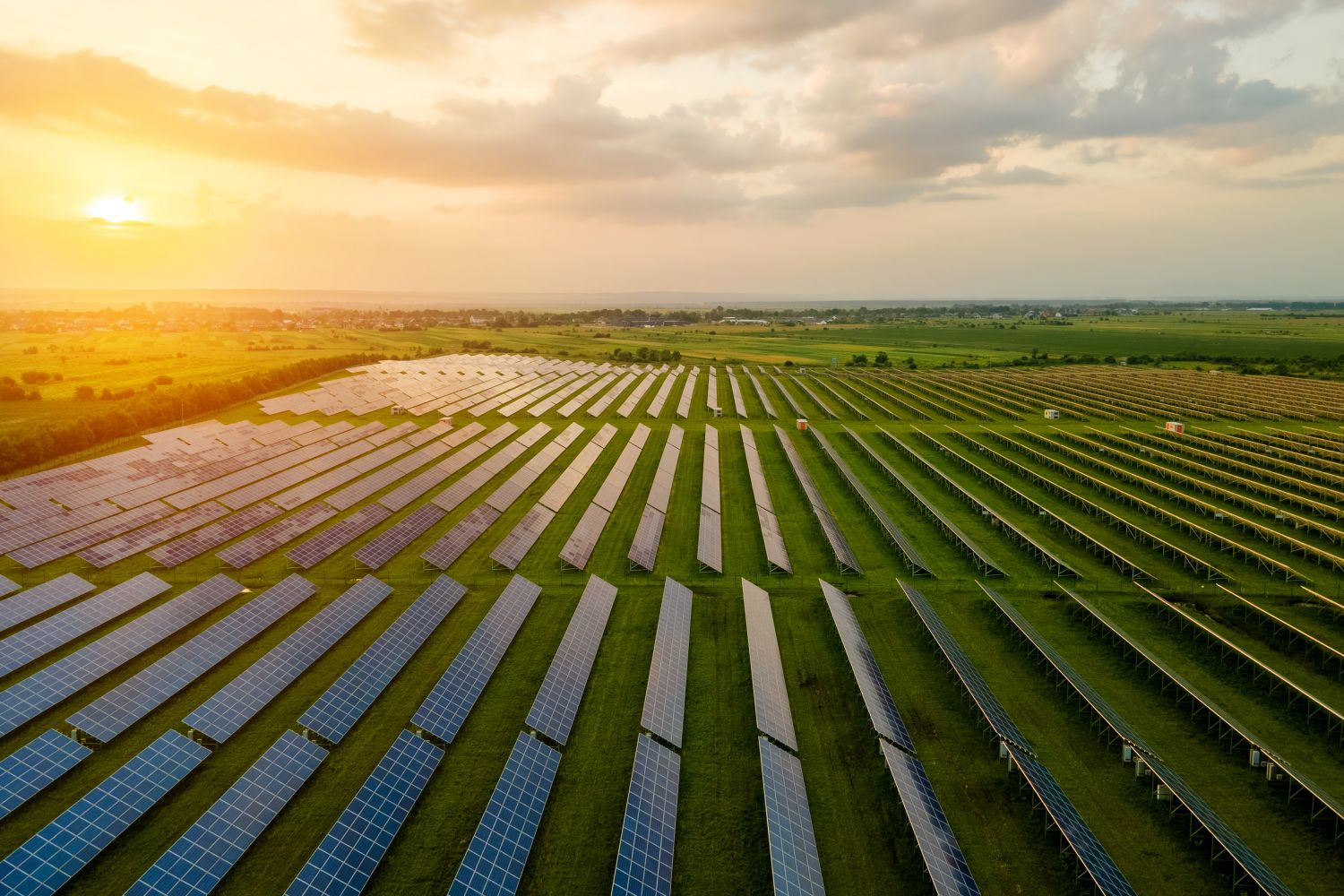 Luftaufnahme eines großen Elektrizitätswerks mit vielen Reihen von Photovoltaikmodulen zur Erzeugung sauberer ökologischer elektrischer Energie am Morgen.